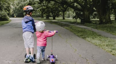 enfants frère et soeur font de la trottinette au parc