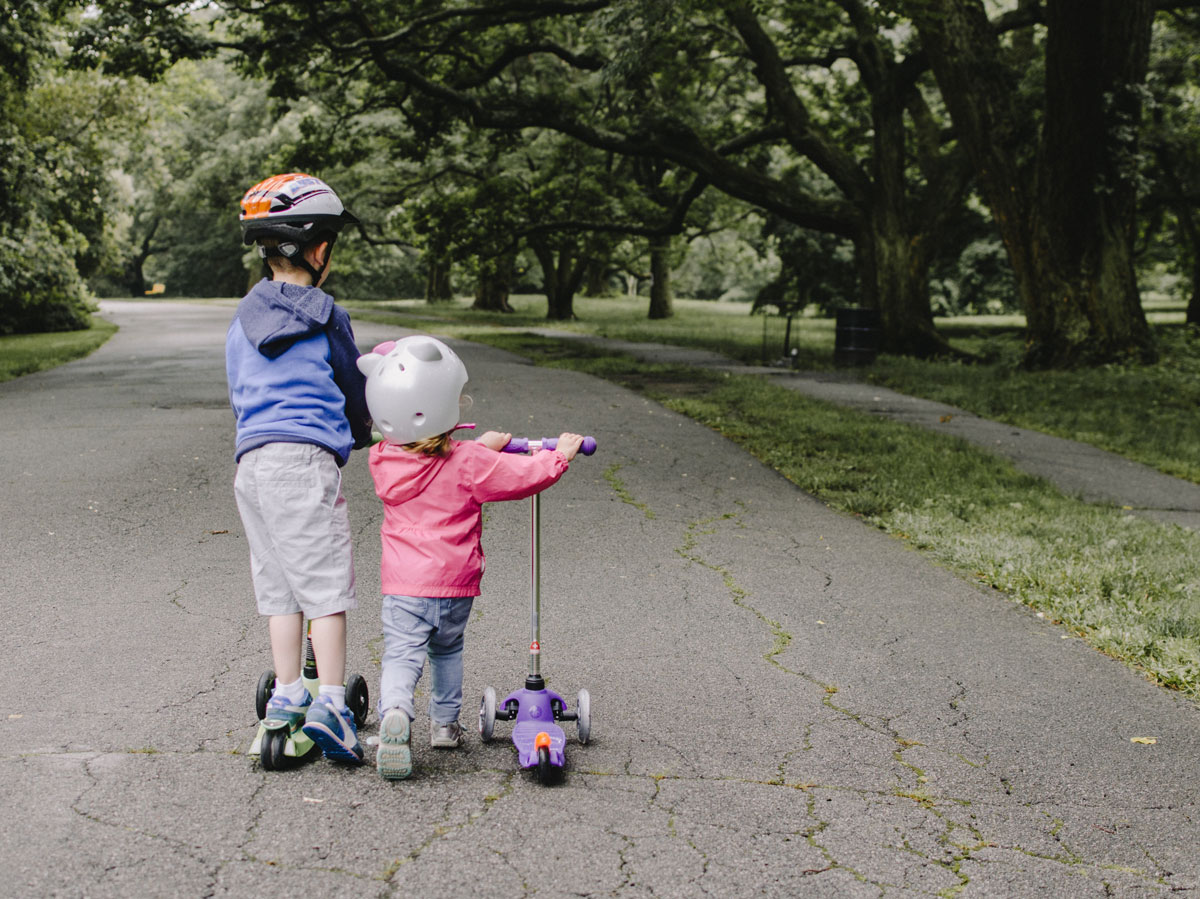 enfants frère et soeur font de la trottinette au parc