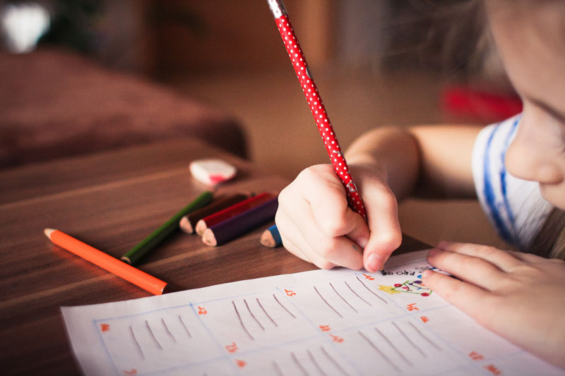 enfant en train de dessiner au crayon service de baby sitter sortie d'école lyon