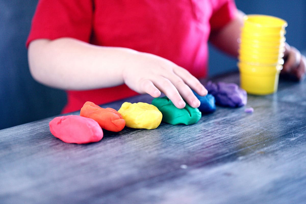 enfant en train de jouer à la pâte à modeler activités nounou