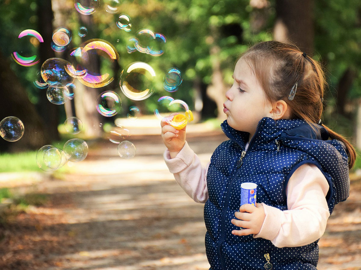 petite fille qui fait des bulles de savon garde à domicile babysitting