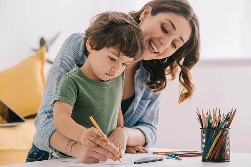 baby sitter fait du dessin avec un enfant garde à domicile